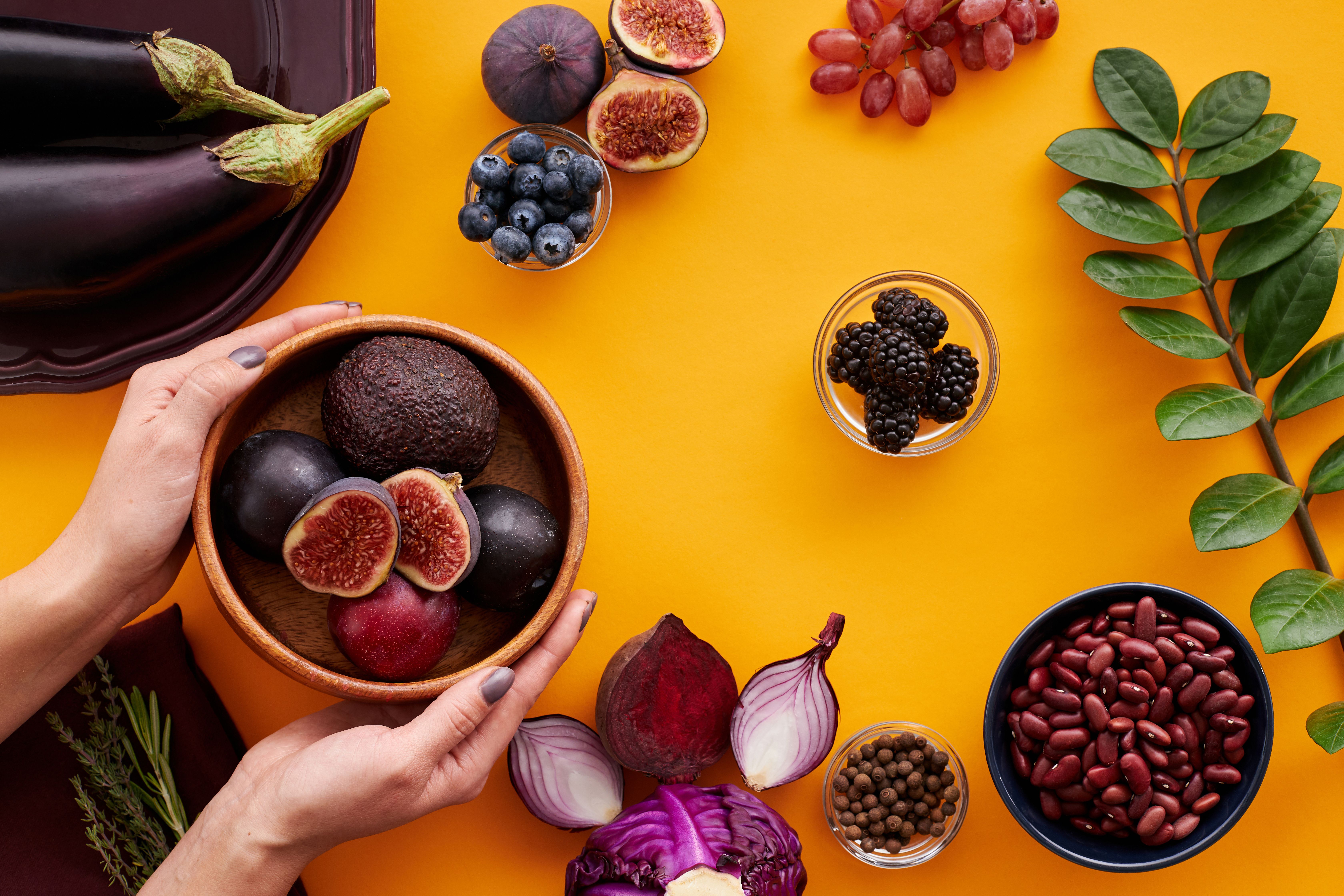 Diverse group of middle-aged and senior citizens sharing a meal with leafy greens, fatty fish, nuts, berries, and green tea to boost memory and concentration